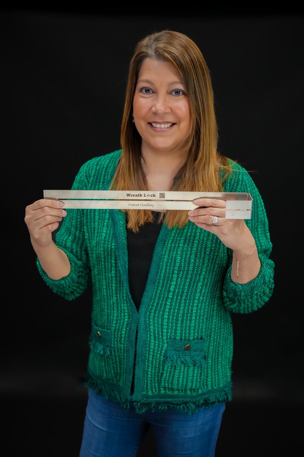 Maria D., founder of The Wreath Meshine, holding the engraved Wreath Lock